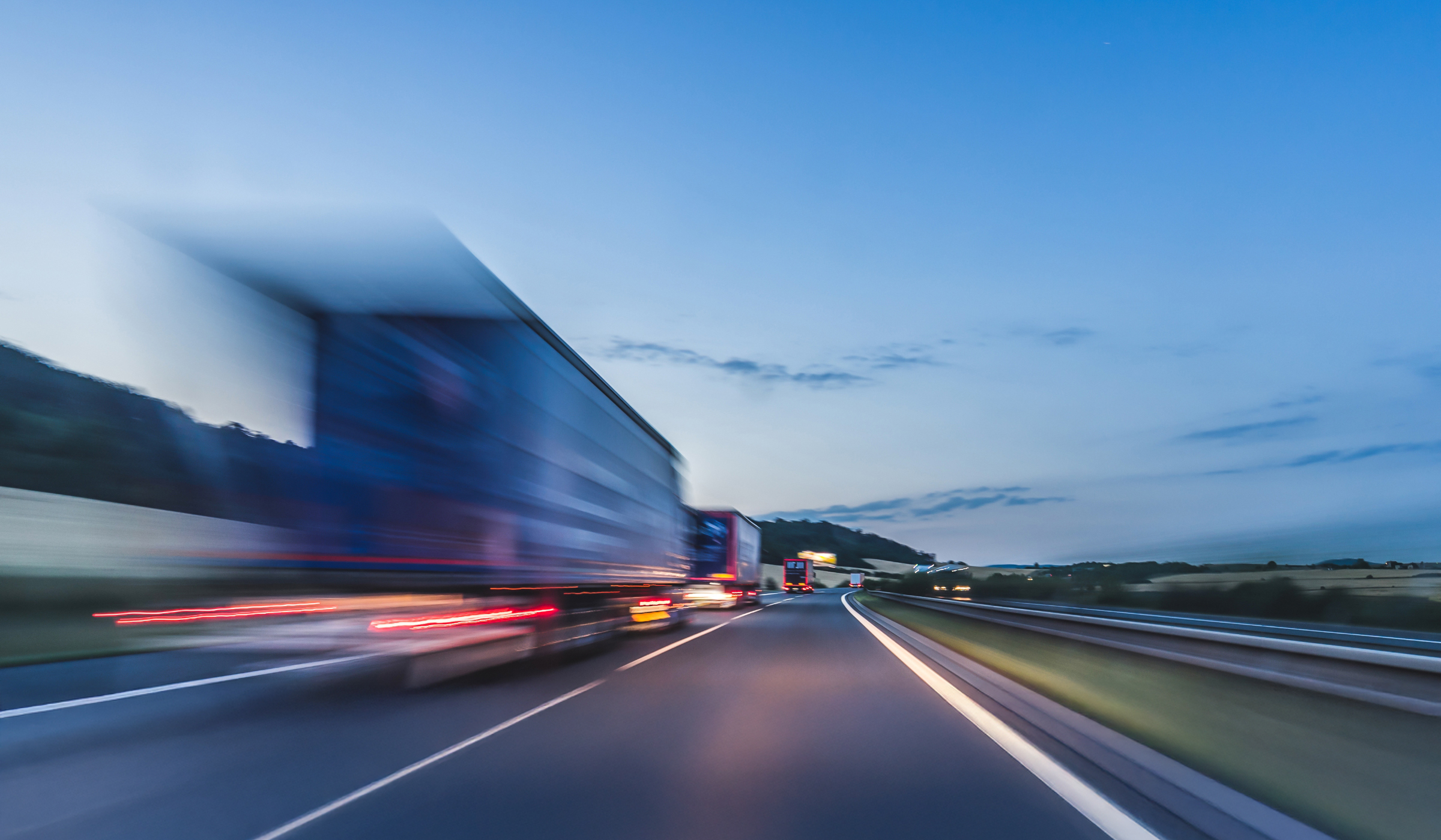 Background photograph of a highway, trucks on a highway, motion blur, light trails timelapse-of-a-busy-street-in-an-urban-area-2025-02-02-21-25-49-utc